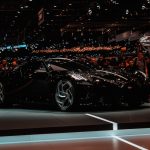 black sports car parked beside crowd