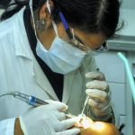 femme tenant un miroir de dentiste