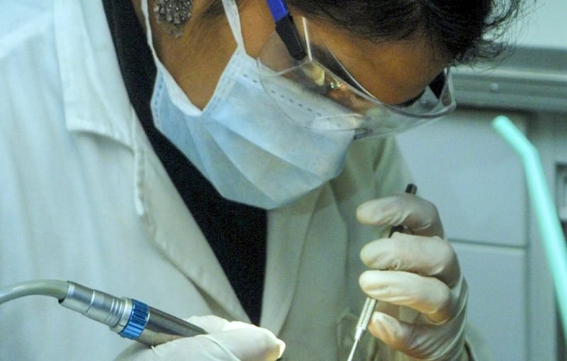 femme tenant un miroir de dentiste