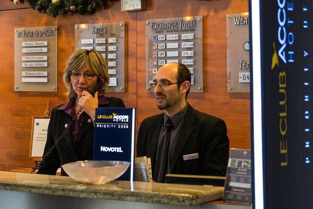 Deux employés d'accueil à la réception d'un hôtel moderne