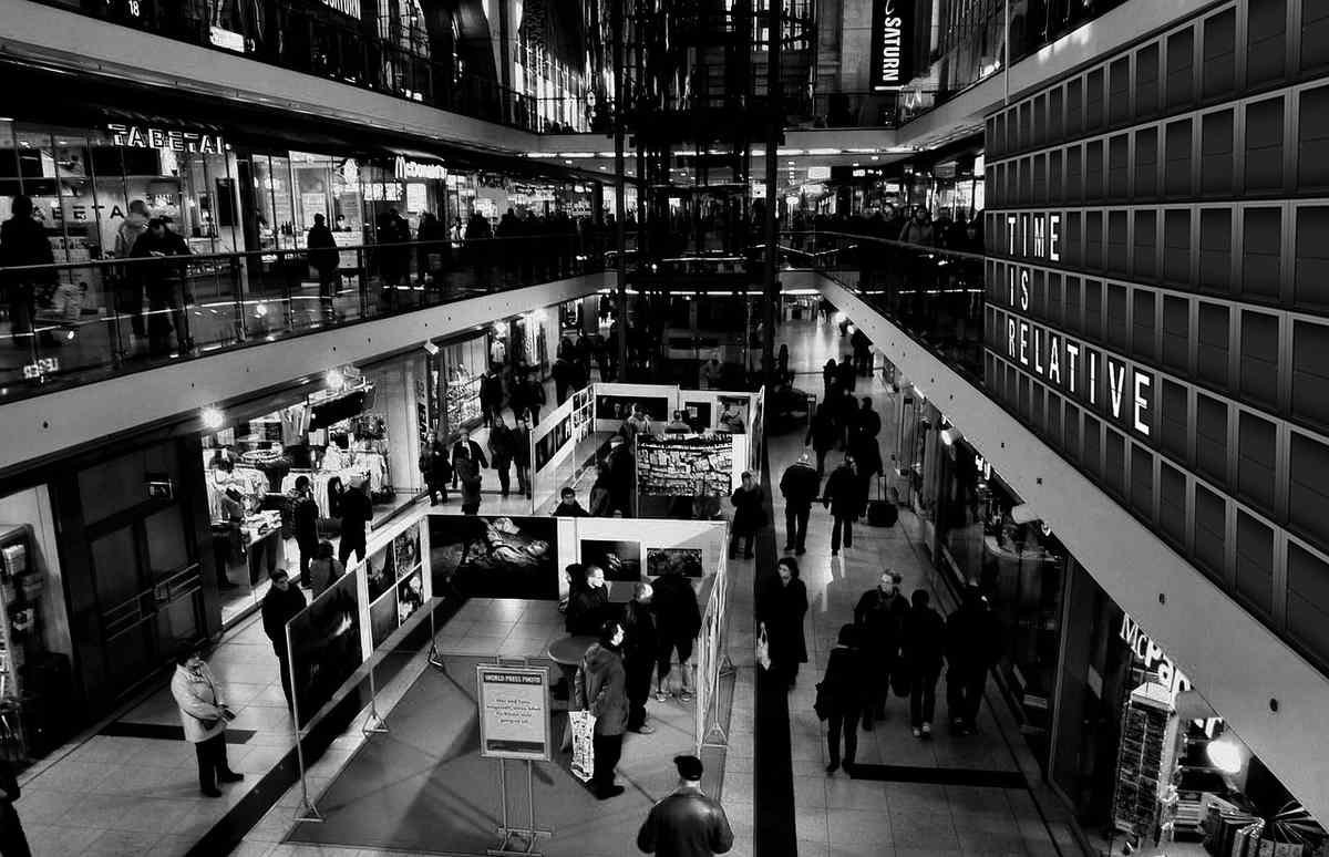 Vue intérieure d'un centre commercial animé, clients et boutiques visibles