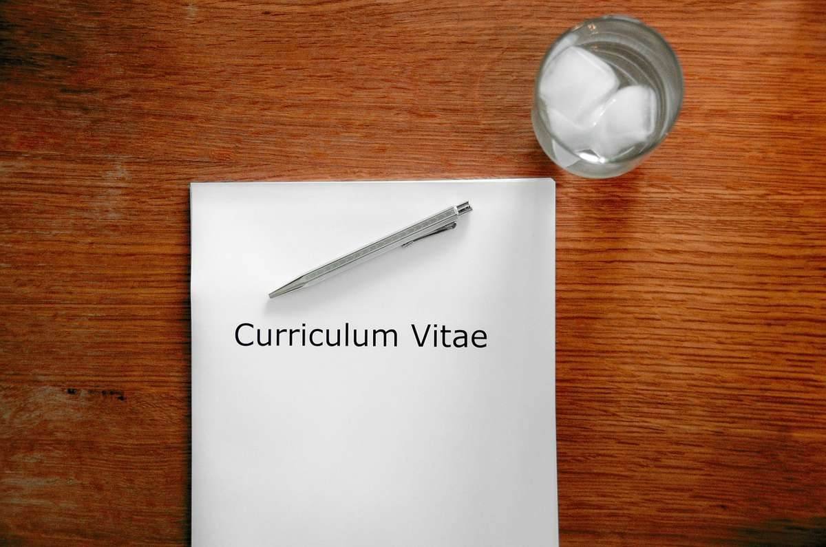 Curriculum Vitae sur une table avec un stylo et un verre d'eau