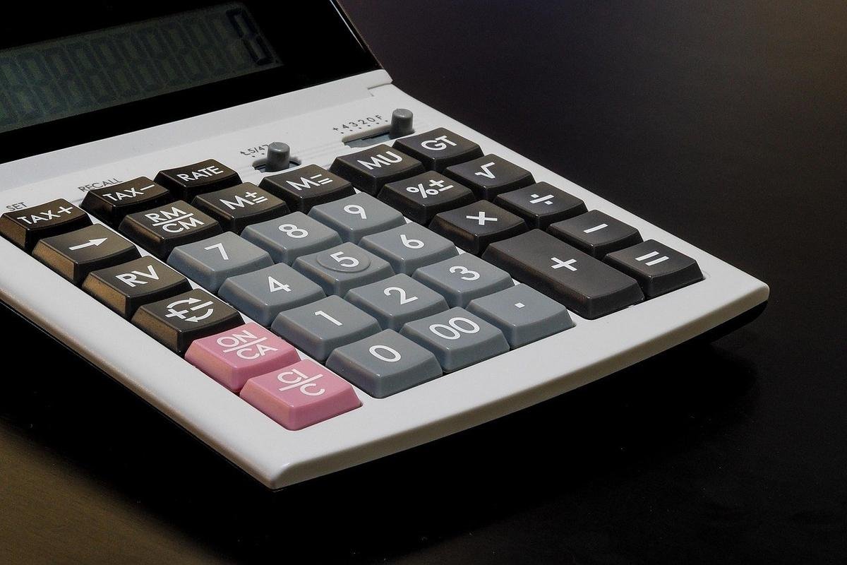 Calculatrice sur une surface sombre, écran éteint, boutons colorés